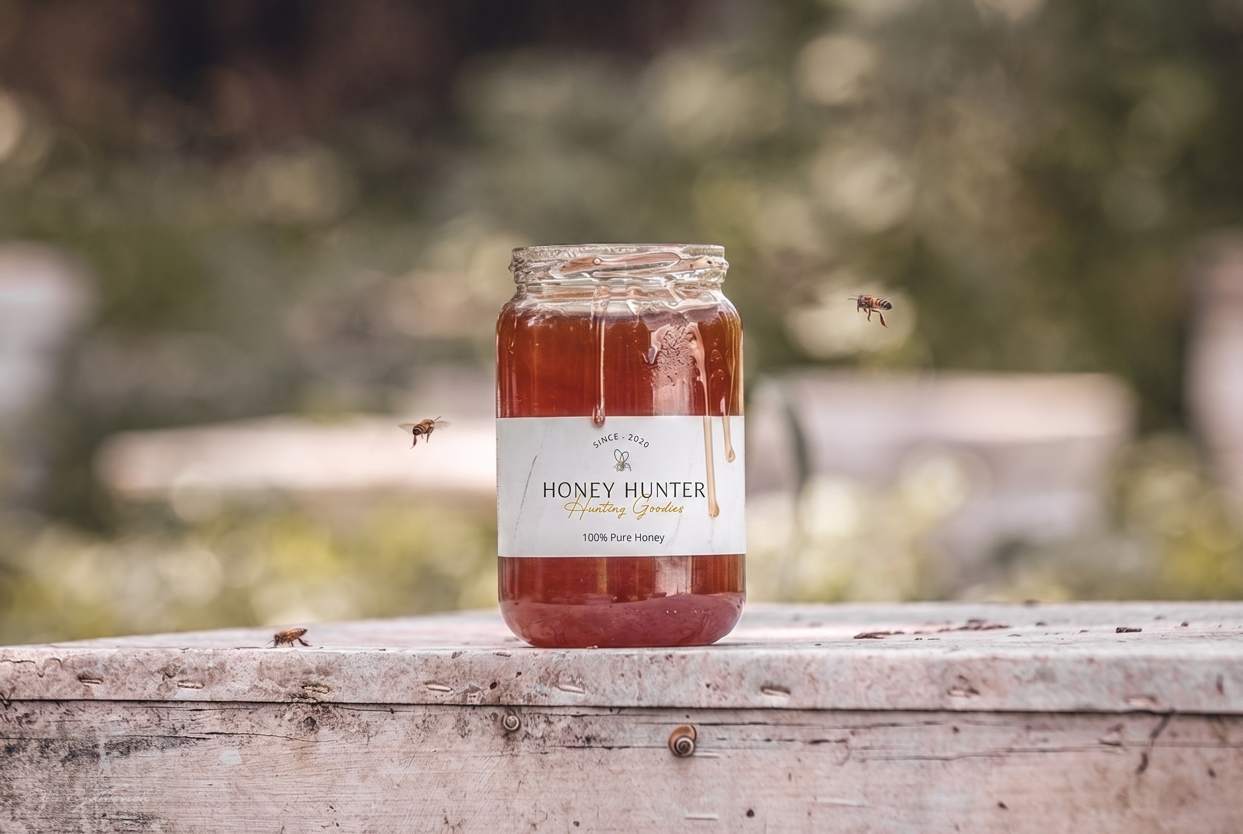 ידיים מחזיקות תווית מוצר של Honey Hunter, עם צנצנת דבש וסבון על שולחן עץ עמוס במוצרים נוספים.